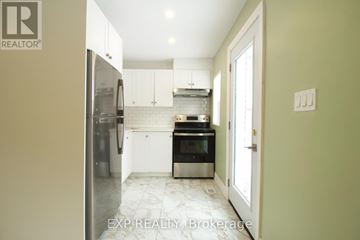London East (East M) duplex for rent - A kitchen with a refrigerator, oven, and microwave.