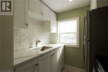 London apartment for rent - A kitchen with white cabinets and a green wall.