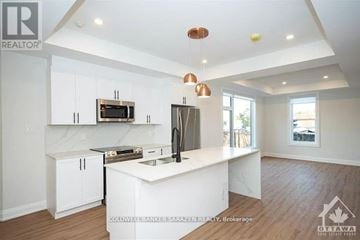 Ottawa apartment for rent - A modern kitchen with white cabinets and a wooden floor.
