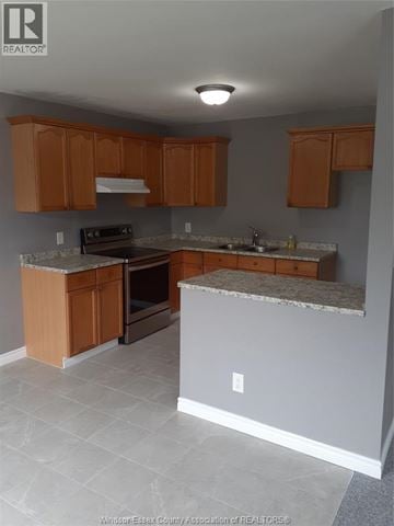Windsor apartment for rent - A kitchen with wooden cabinets and a granite countertop.