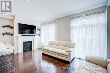 Markham (Wismer) townhouse for rent - A living room with a white couch and a fireplace.
