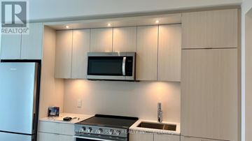 Toronto (Islington-City Centre West) condo for rent - A kitchen with a refrigerator, microwave, and sink.