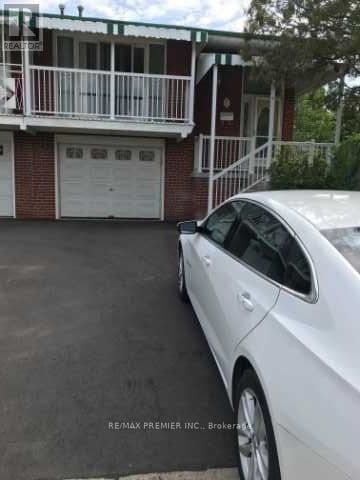 Toronto (Glenfield-Jane Heights) apartment for rent - A white car is parked in front of a red brick house.