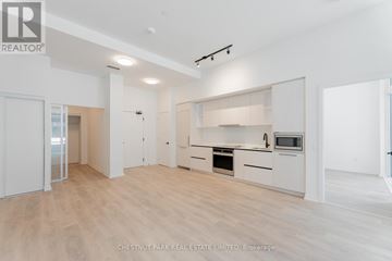 Toronto (Dovercourt-Wallace Emerson-Junction) condo for rent - A spacious kitchen with white cabinets and a microwave above the oven.
