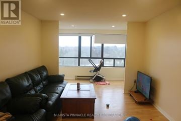 London North (North C) condo for rent - A living room with a black leather couch and a television.