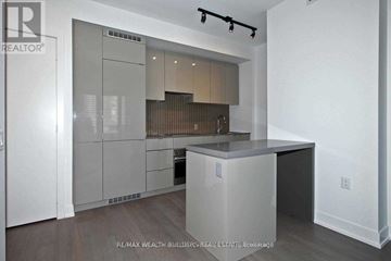 Toronto (Bay Street Corridor) condo for rent - A modern kitchen with white cabinets and a wooden floor.