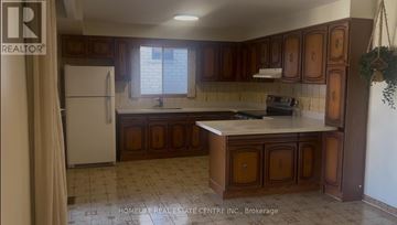 Toronto (Stonegate-Queensway) apartment for rent - A kitchen with brown cabinets and a white refrigerator.