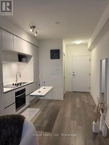 Richmond Hill condo for rent - A modern kitchen with white cabinets and a wooden floor.