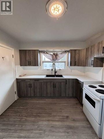 Lethbridge apartment for rent - A kitchen with a white stove and wooden cabinets.