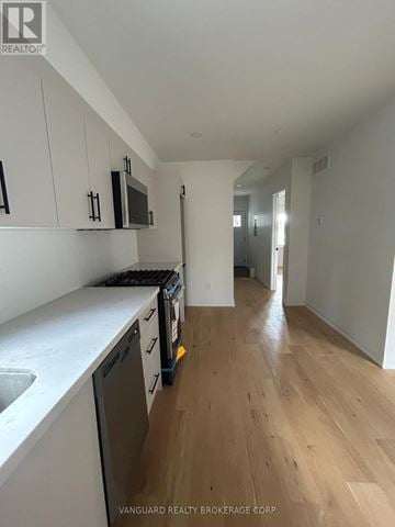 Toronto (Lansing-Westgate) apartment for rent - A kitchen with white cabinets and a wooden floor.