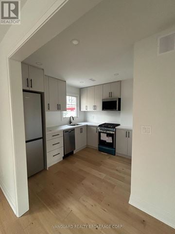 Toronto (Lansing-Westgate) apartment for rent - A kitchen with white cabinets and a wooden floor.