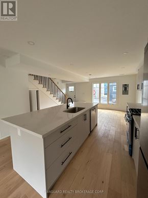 Toronto (Lansing-Westgate) apartment for rent - A modern kitchen with wooden floors and white cabinetry.