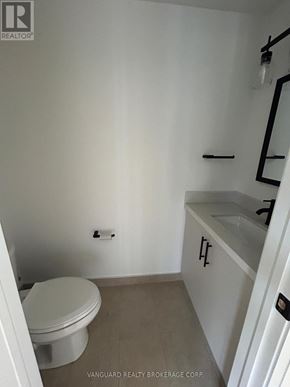 Toronto (Lansing-Westgate) apartment for rent - A white toilet in a small bathroom with a white cabinet and a mirror.