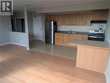 Hamilton condo for rent - A kitchen with wooden cabinets and a refrigerator.