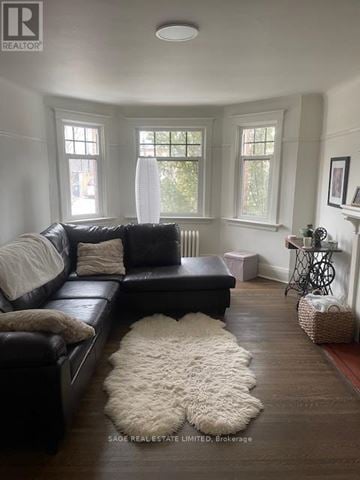 Toronto (Yonge-St. Clair) townhouse for rent - A living room with a black leather couch and a white fluffy rug.