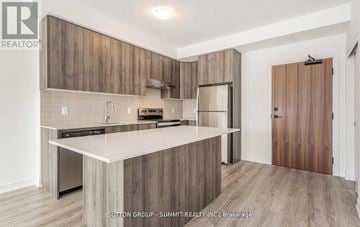 Hamilton (Stoney Creek) condo for rent - A modern kitchen with wooden cabinets and a white countertop.