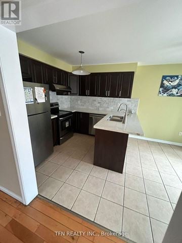 Toronto (Rouge) townhouse for rent - A kitchen with black cabinets and a white refrigerator.
