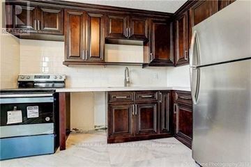 Toronto (Malvern) condo for rent - A kitchen with wooden cabinets and a refrigerator.
