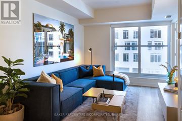 Toronto (Waterfront Communities) condo for rent - A living room with a blue couch and a painting of a building on the wall.