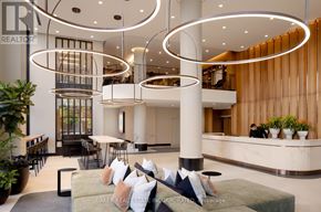 Toronto (Waterfront Communities) condo for rent - A large, modern room with a circular light fixture and a long table with chairs.