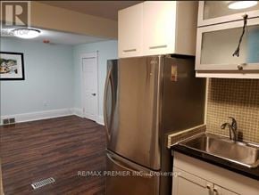 Oshawa (O'neill) apartment for rent - A kitchen with a stainless steel refrigerator and wooden flooring.