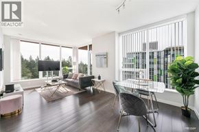 Vancouver apartment for rent - A living room with a grey sofa and a glass table.