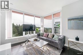 Vancouver apartment for rent - A living room with a grey couch and a large window.