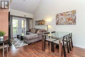 Collingwood condo for rent - A living room with a glass table and chairs, a grey couch, and a painting on the wall.
