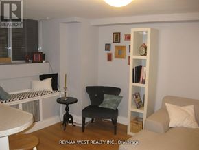 Toronto (Oakwood Village) fourplex for rent - A living room with a black chair and a white bookshelf.