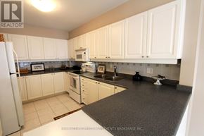 Vaughan (Crestwood-Springfarm-Yorkhill) townhouse for rent - A kitchen with white cabinets and a black countertop.