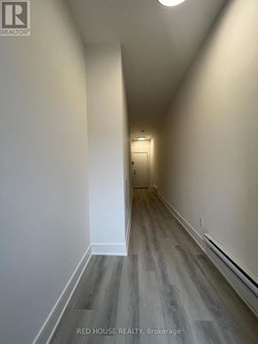 St. Catharines (Oakdale) townhouse for rent - A hallway with wood flooring and white walls.