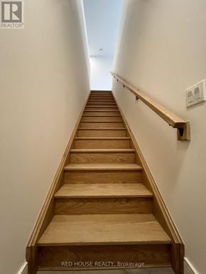 St. Catharines (Oakdale) townhouse for rent - A long flight of wooden stairs leads up to a light at the end.