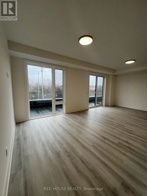 St. Catharines (Oakdale) townhouse for rent - A spacious room with wooden flooring and sliding glass doors.