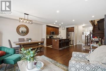 Russell townhouse for rent - A living room with a green couch and a coffee table with a vase of flowers on it.