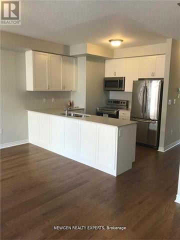 Brampton (Northwest Brampton) townhouse for rent - A kitchen with white cabinets and a wooden floor.