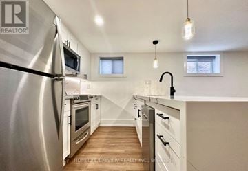 Toronto (The Beaches) multi-family for rent - A modern kitchen with a stainless steel refrigerator and wooden flooring.