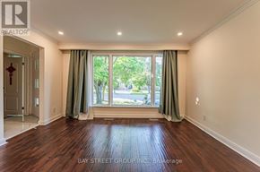 Richmond Hill (Crosby) apartment for rent - A room with wooden flooring and a large window with green curtains.