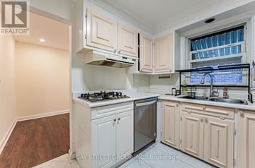 Richmond Hill (Crosby) apartment for rent - A kitchen with white cabinets and a stove top oven.