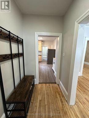 Ottawa triplex for rent - A hallway with a wooden floor and white walls.