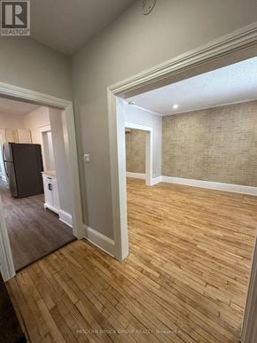 Ottawa triplex for rent - A room with wooden flooring and a brick wall.