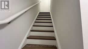 Toronto (Birchcliffe-Cliffside) townhouse for rent - A staircase with a white railing and wooden steps.