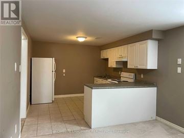 Barrie (Painswick South) apartment for rent - A kitchen with a white refrigerator and cabinets.