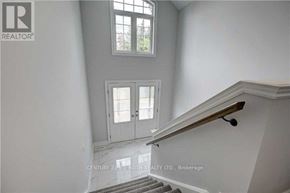 Barrie (Ardagh) apartment for rent - A staircase with a wooden handrail and a tiled floor leads to a door with a window above it.