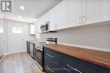 St. Thomas multi-family for rent - A kitchen with white cabinets and a wooden countertop.
