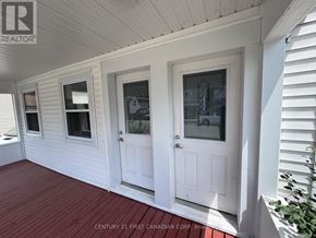 St. Thomas multi-family for rent - A white house with a porch and two doors.