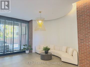 Toronto (Cliffcrest) condo for rent - A living room with a white couch and a hanging light fixture.