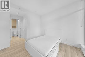 Burnaby apartment for rent - A bedroom with a bed, wooden floors, and a white wall.