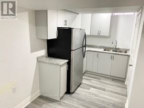 Mississauga (East Credit) apartment for rent - A kitchen with a black fridge and white cabinets.