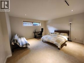 Vancouver apartment for rent - A bedroom with a bed, chair, and window.
