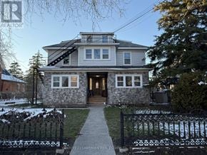 Prince Edward County (Picton Ward) multi-family for rent - A house with a grey roof and a stone wall in front.
